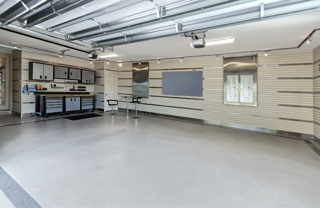 Designed garage with Slatwall, a workbench, a drinks table and chairs, and track lighting