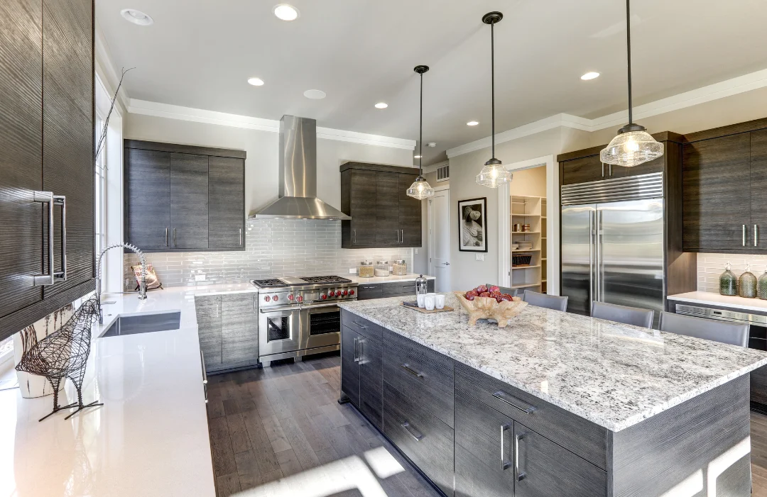 Modern kitchen in greys, browns and earthy textures (wood floors, wood cabinets), quartz countertops and stainless appliances.